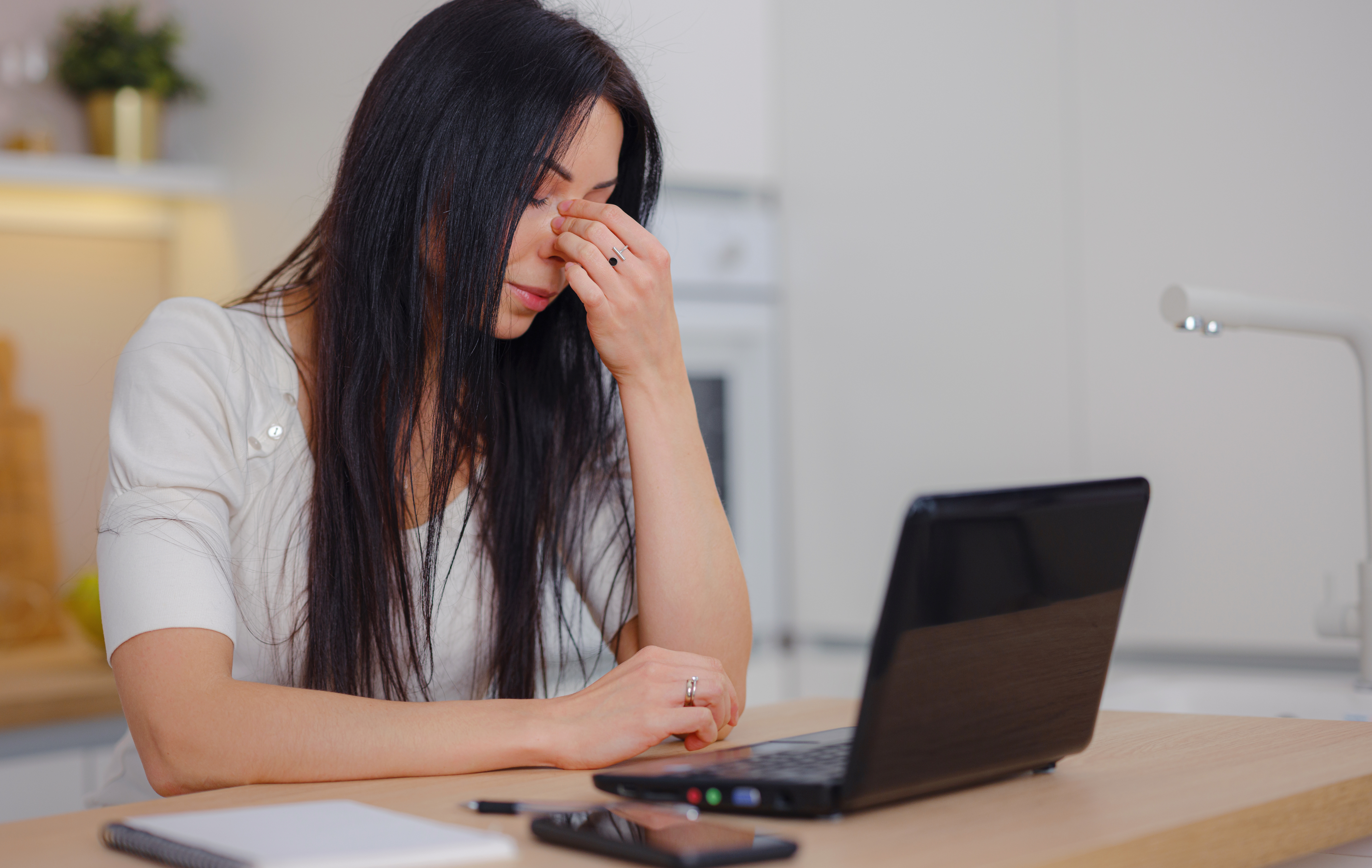 A frustrated woman is depicted holding her sinuses while searching for answers on a laptop. This image represents the emotional and physical distress caused by female hair loss. It symbolizes the quest for understanding and solutions. The image signifies that the hormone replacement therapy website can provide valuable information and assistance in identifying the underlying causes of female hair loss. It conveys the message that the clinic is dedicated to helping patients find answers and offers potential solutions for their hair loss concerns.
